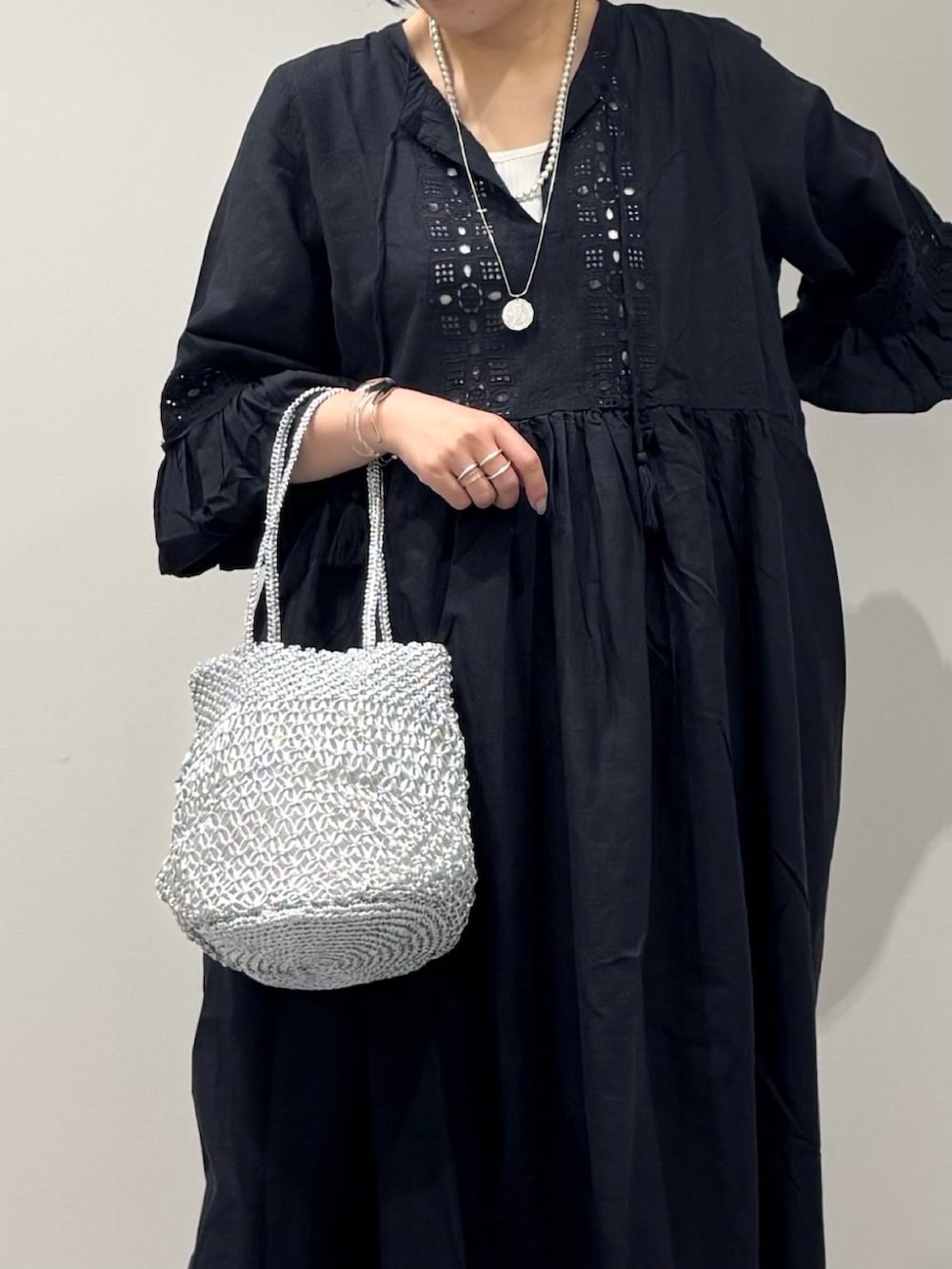 ブラック系のワンピース、シルバー系のかごバッグ、ブラック系のサンダルを着用したレディースの秋コーディネートの10枚目の写真