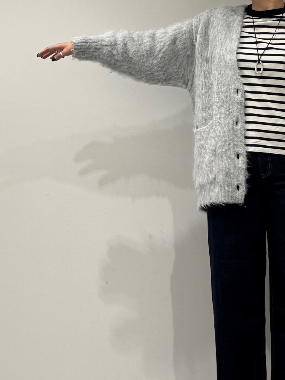 パープル系のトートバッグ、ブルー系のデニムパンツ、ブラック系のTシャツ/カットソーを着用したレディースの冬コーディネートの6枚目の写真