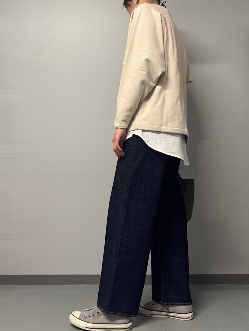 ベージュ系のスウェット、ブルー系のデニムパンツ、グレー系のトートバッグを着用したレディースの冬コーディネートの6枚目の写真