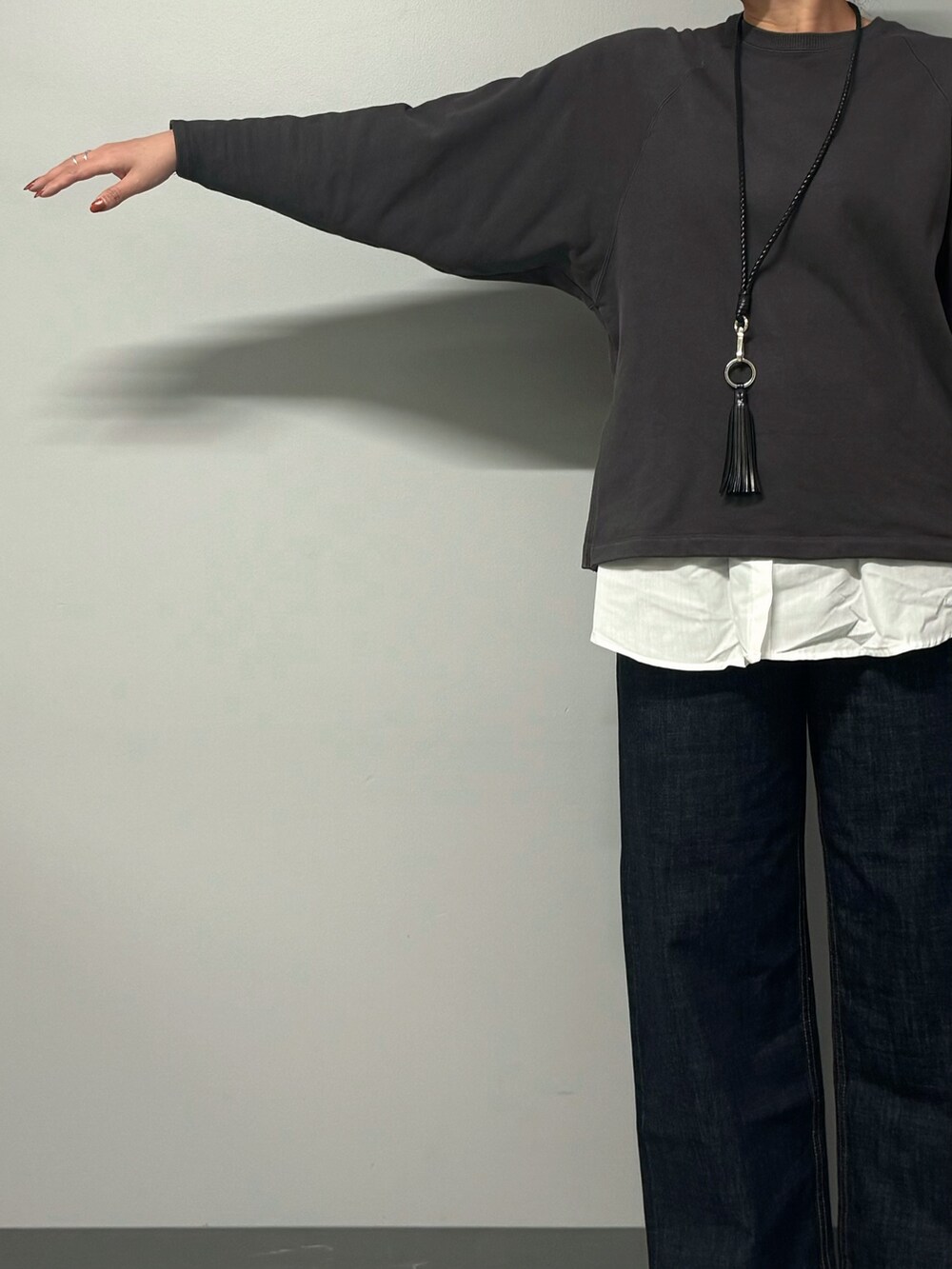 グレー系のスウェット、ブルー系のデニムパンツ、ブラック系のボストンバッグを着用したレディースの秋コーディネートの4枚目の写真