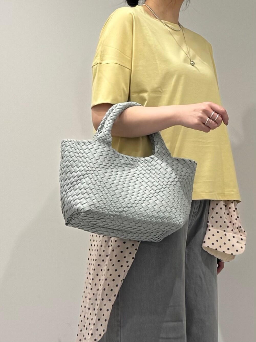 グレー系のトートバッグ、グレー系のデニムパンツ、ホワイト系のシャツ/ブラウスを着用したレディースの春コーディネートの8枚目の写真