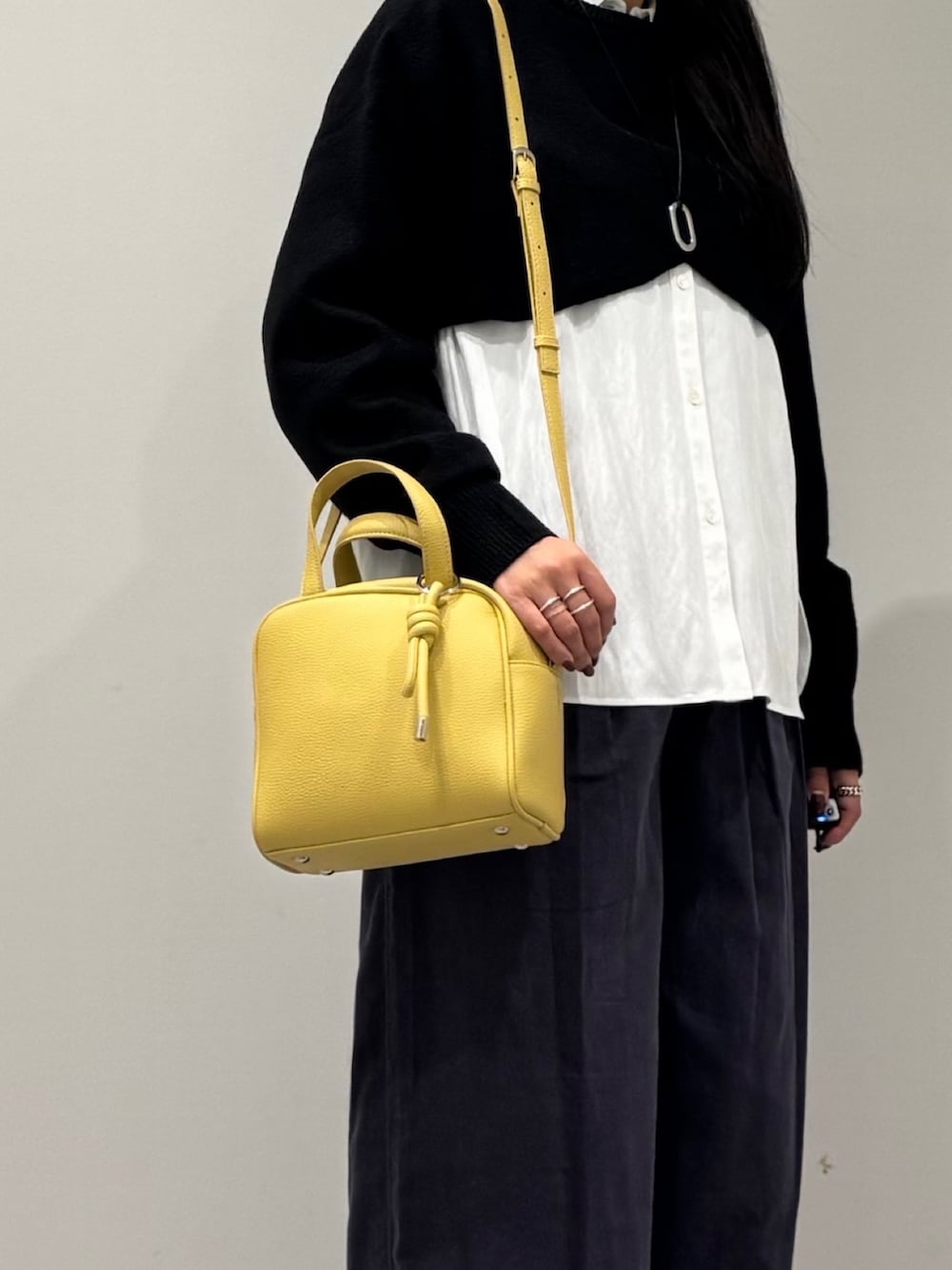 イエロー系のボストンバッグ、ブラック系のローファー、ホワイト系のシャツ/ブラウスを着用したレディースの冬コーディネートの8枚目の写真