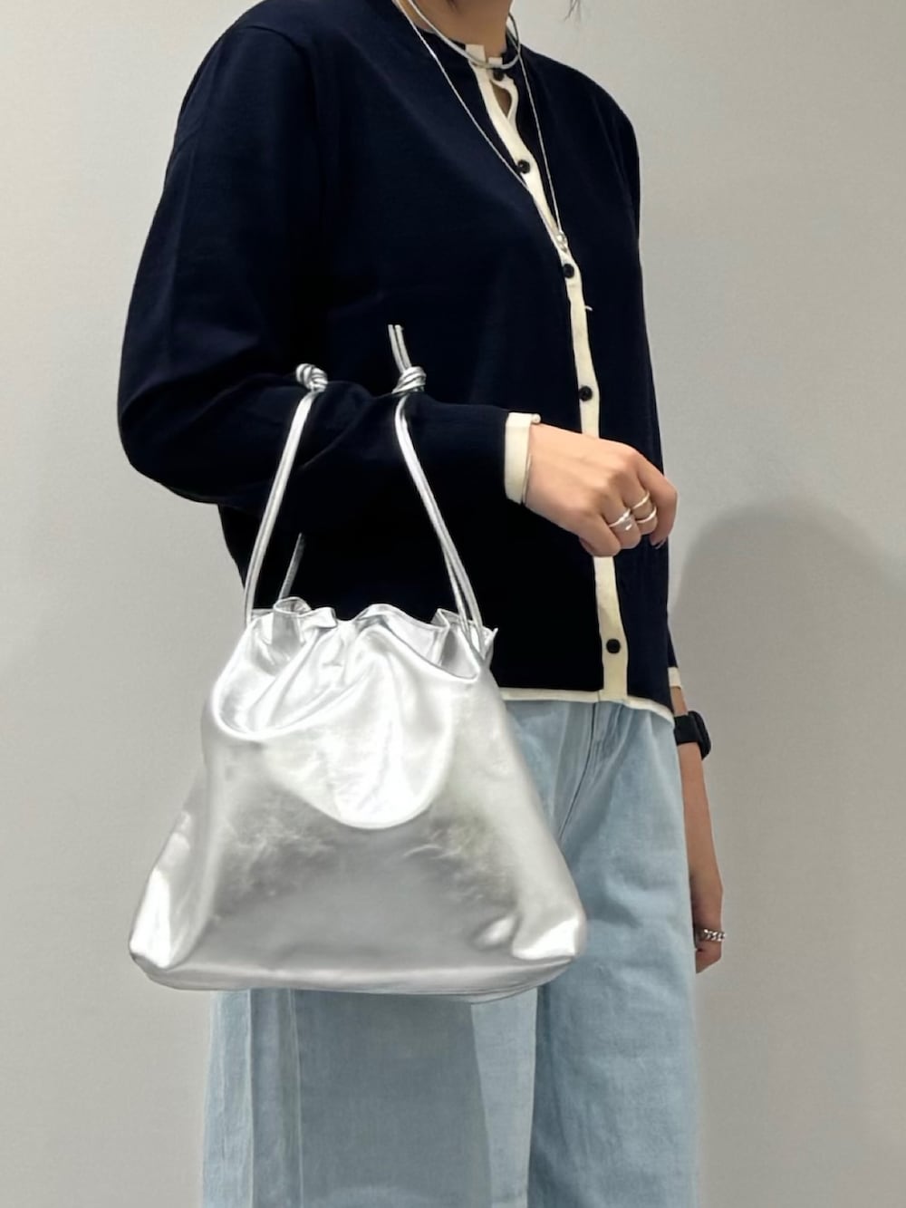 シルバー系のショルダーバッグ、ブルー系のデニムパンツ、ブルー系のカーディガン/ボレロを着用したレディースの春コーディネートの8枚目の写真