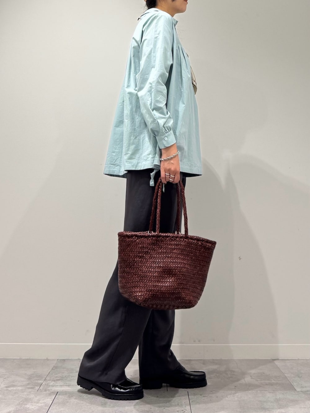 ブラウン系のトートバッグ、グレー系のその他パンツ、ブラック系のローファーを着用したレディースの秋コーディネートの2枚目の写真