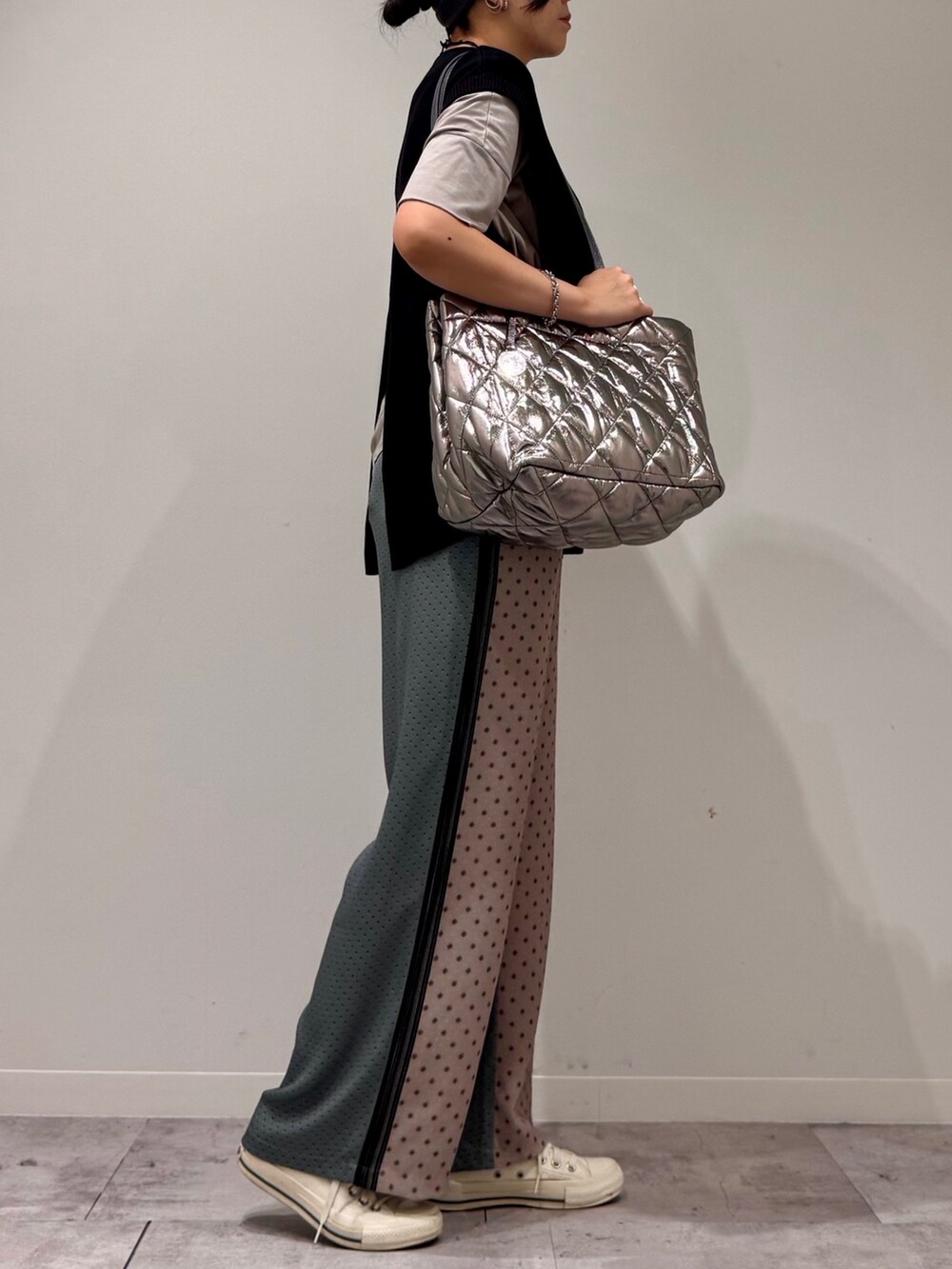 シルバー系のトートバッグ、ベージュ系のその他パンツ、ブラック系のベストを着用したレディースの秋コーディネートの2枚目の写真