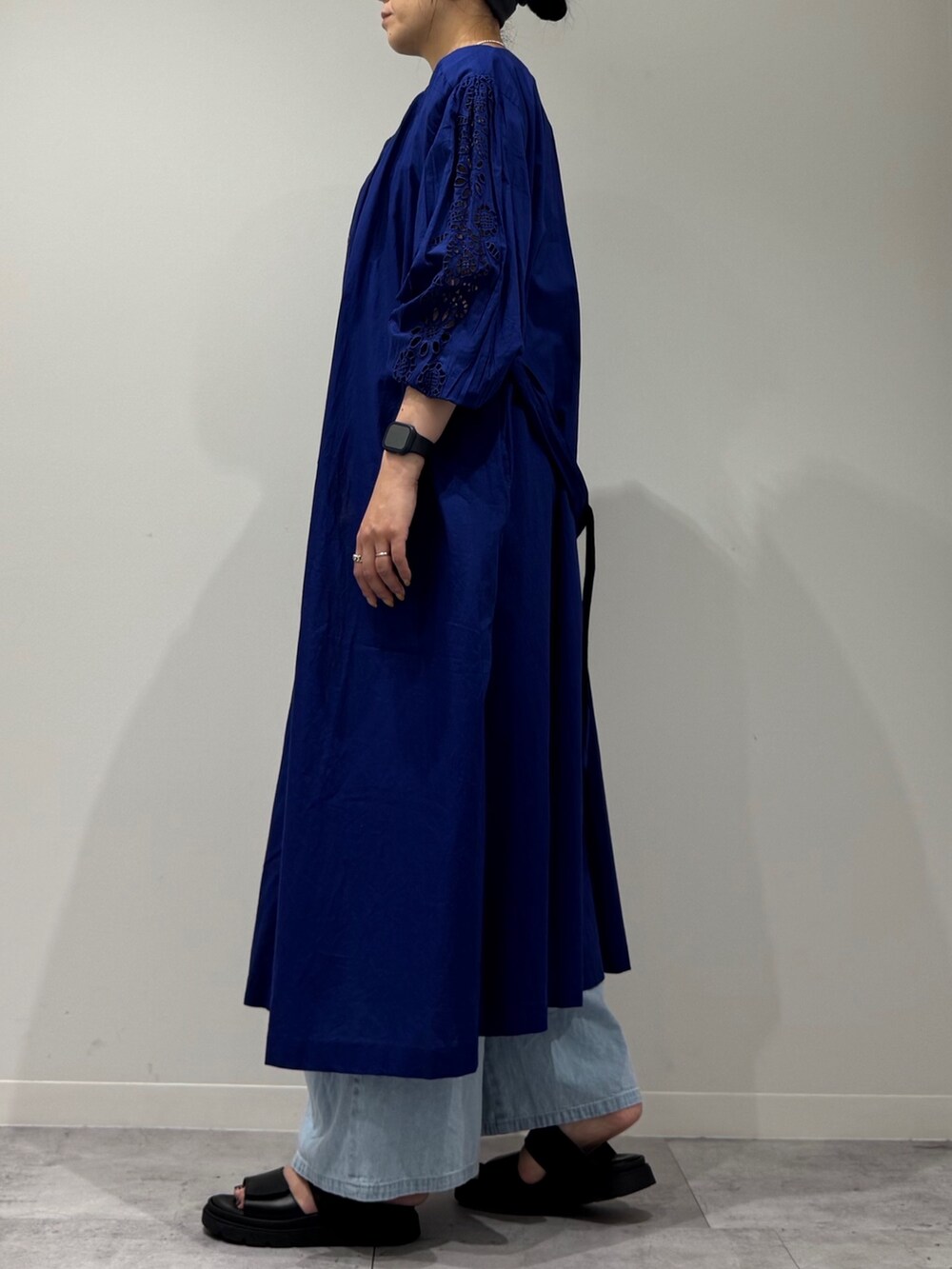 ホワイト系のトートバッグ、ブルー系のデニムパンツ、ブラック系のサンダルを着用したレディースの秋コーディネートの6枚目の写真