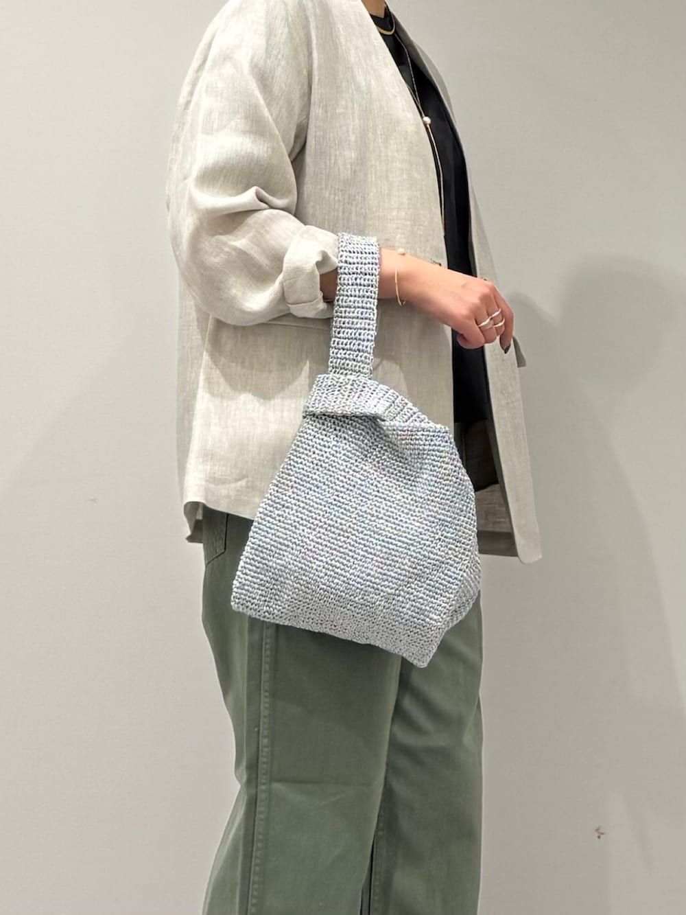 シルバー系のかごバッグ、グリーン系のその他パンツ、ブラック系のローファーを着用したレディースの春コーディネートの7枚目の写真