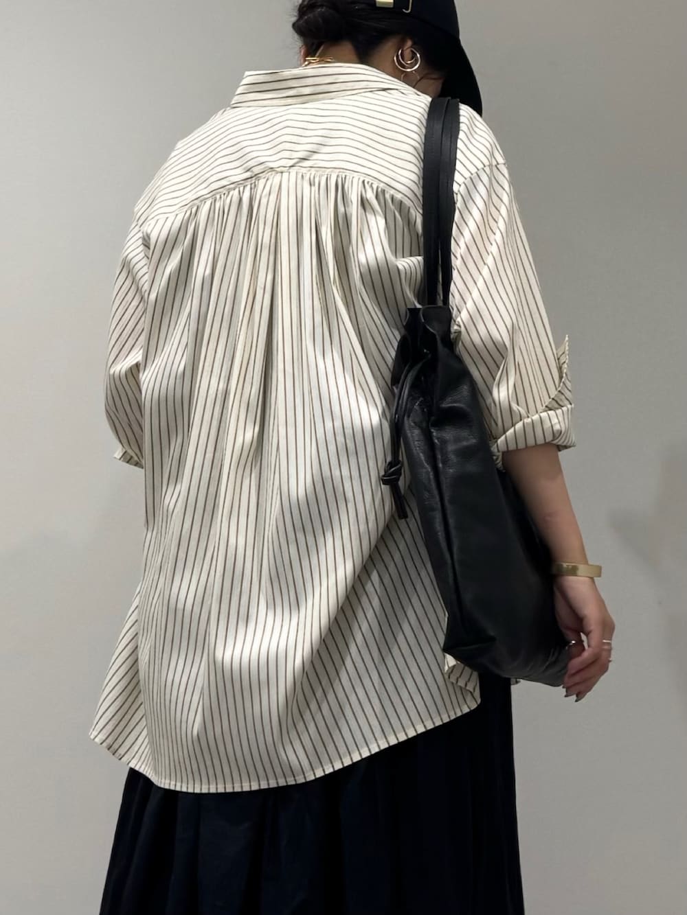 ブラック系のワンピース、ブラック系のサンダル、ブラック系のトートバッグを着用したレディースの夏コーディネートの7枚目の写真