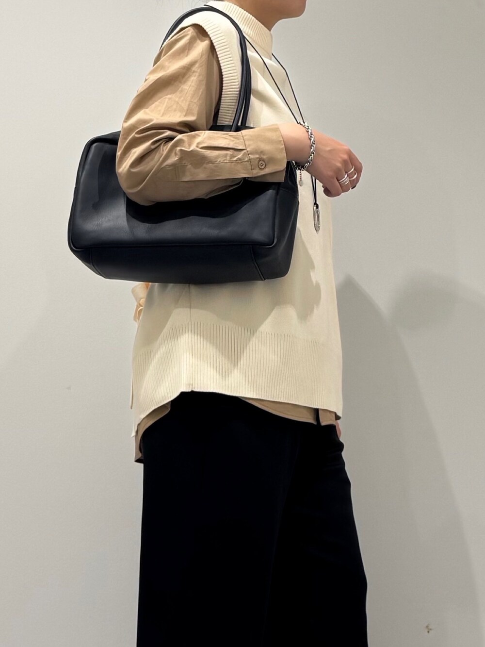 ブラック系のその他パンツ、ホワイト系のベスト、ベージュ系のシャツ/ブラウスを着用したレディースの秋コーディネートの5枚目の写真