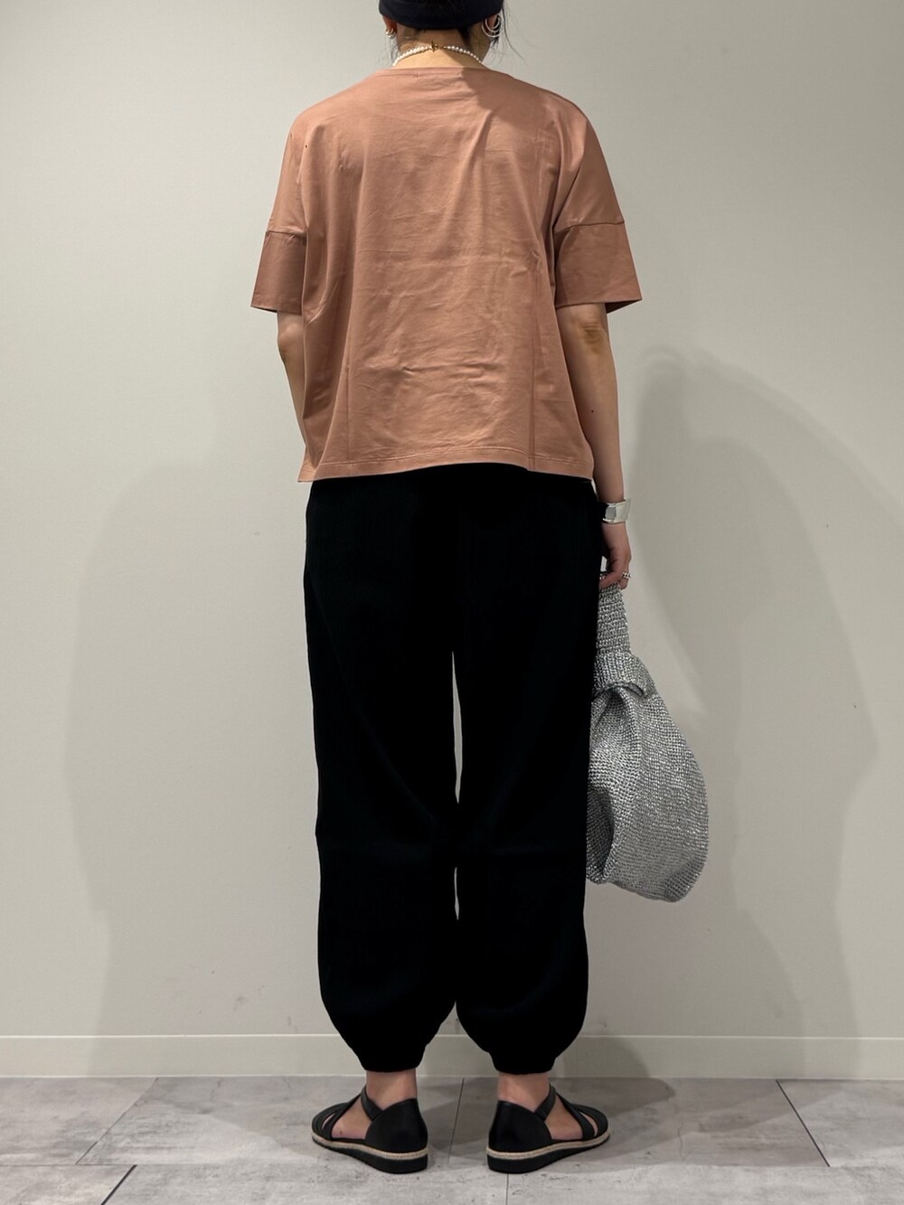 シルバー系のかごバッグ、ブラック系のサンダル、ゴールド系のネックレスを着用したレディースの春コーディネートの4枚目の写真