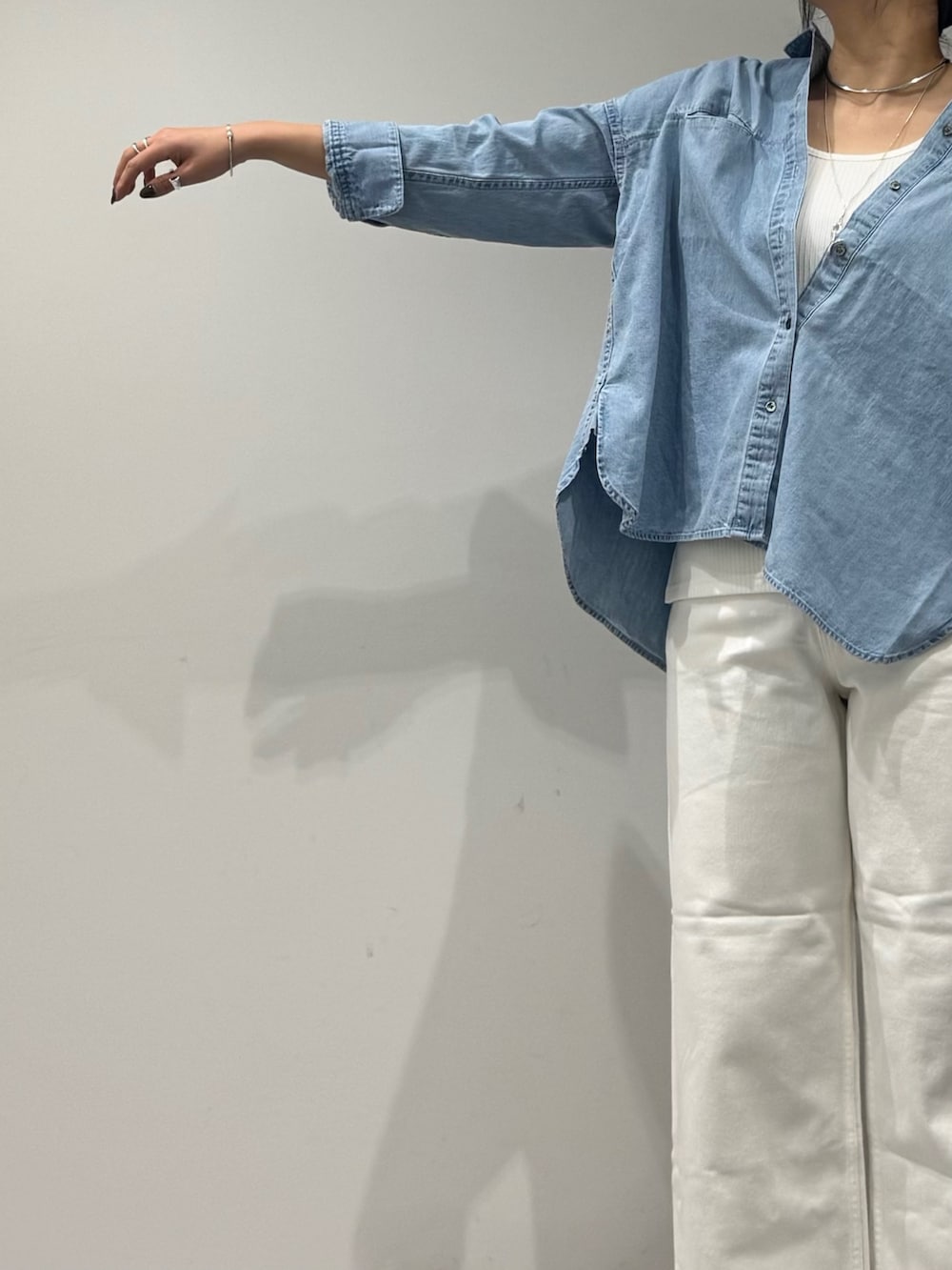 ブラック系のボストンバッグ、ホワイト系のデニムパンツ、ブルー系のシャツ/ブラウスを着用したレディースの春コーディネートの5枚目の写真