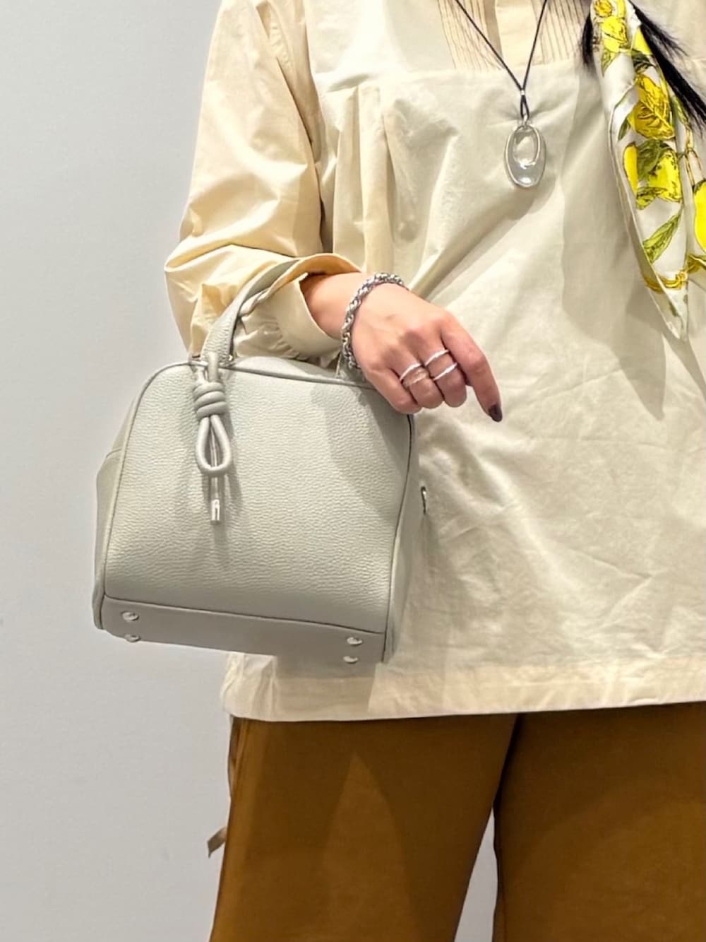 グレー系のボストンバッグ、ホワイト系のシャツ/ブラウス、ブラウン系のその他パンツを着用したレディースの秋コーディネートの8枚目の写真