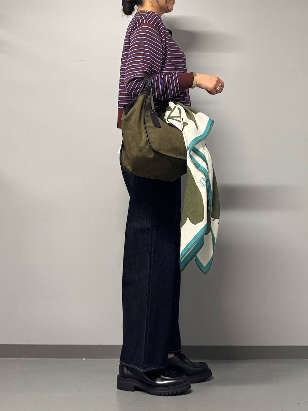ブラック系のパンプス、ブルー系のデニムパンツ、レッド系のカーディガン/ボレロを着用したレディースの秋コーディネートの2枚目の写真