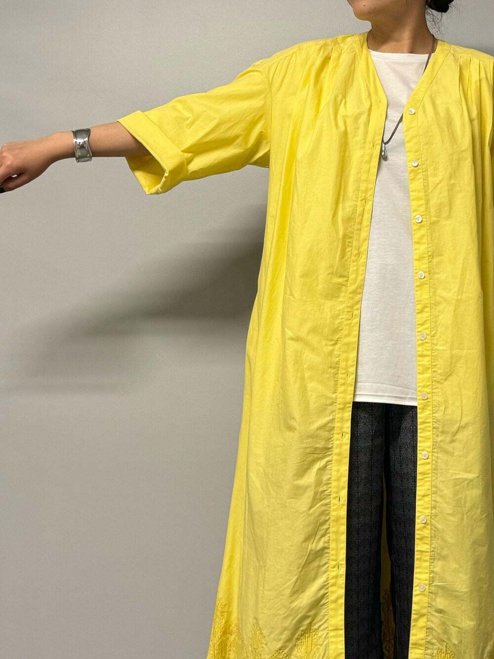 イエロー系のワンピース、ホワイト系のTシャツ/カットソー、ブルー系のその他パンツを着用したレディースの夏コーディネートの3枚目の写真