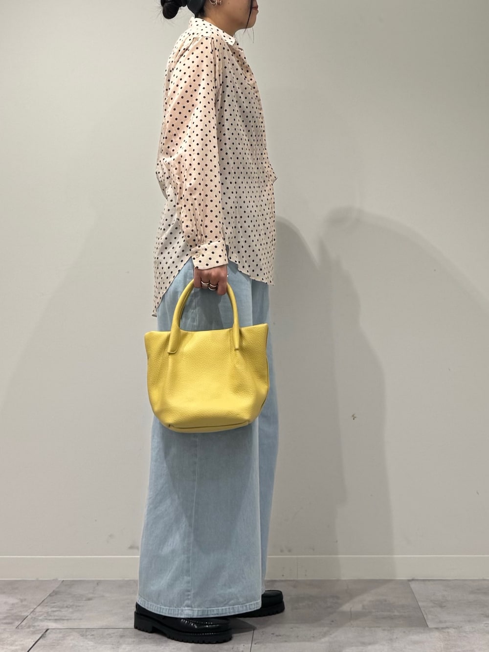 イエロー系のショルダーバッグ、ブルー系のデニムパンツ、ブラック系のローファーを着用したレディースの春コーディネートの2枚目の写真
