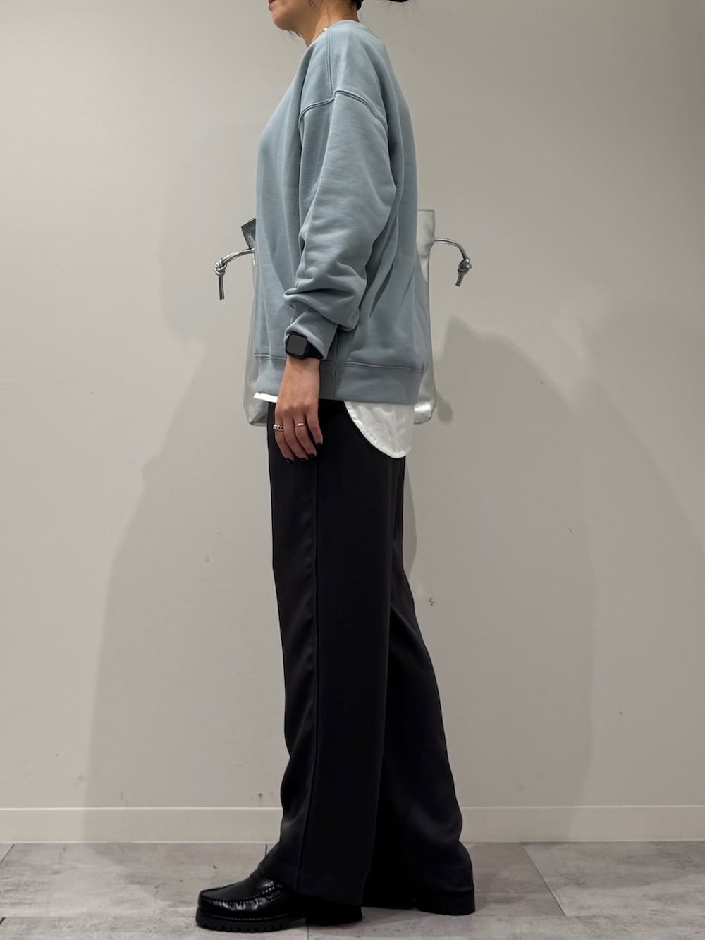 シルバー系のトートバッグ、ブルー系のスウェット、ホワイト系のTシャツ/カットソーを着用したレディースの冬コーディネートの5枚目の写真