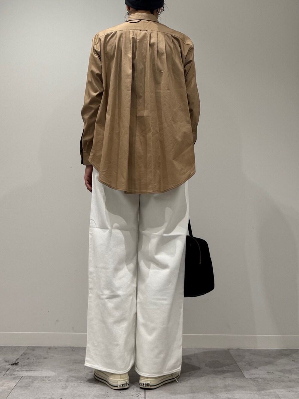 ベージュ系のシャツ/ブラウス、ホワイト系のデニムパンツ、ブラック系のボストンバッグを着用したレディースの秋コーディネートの4枚目の写真