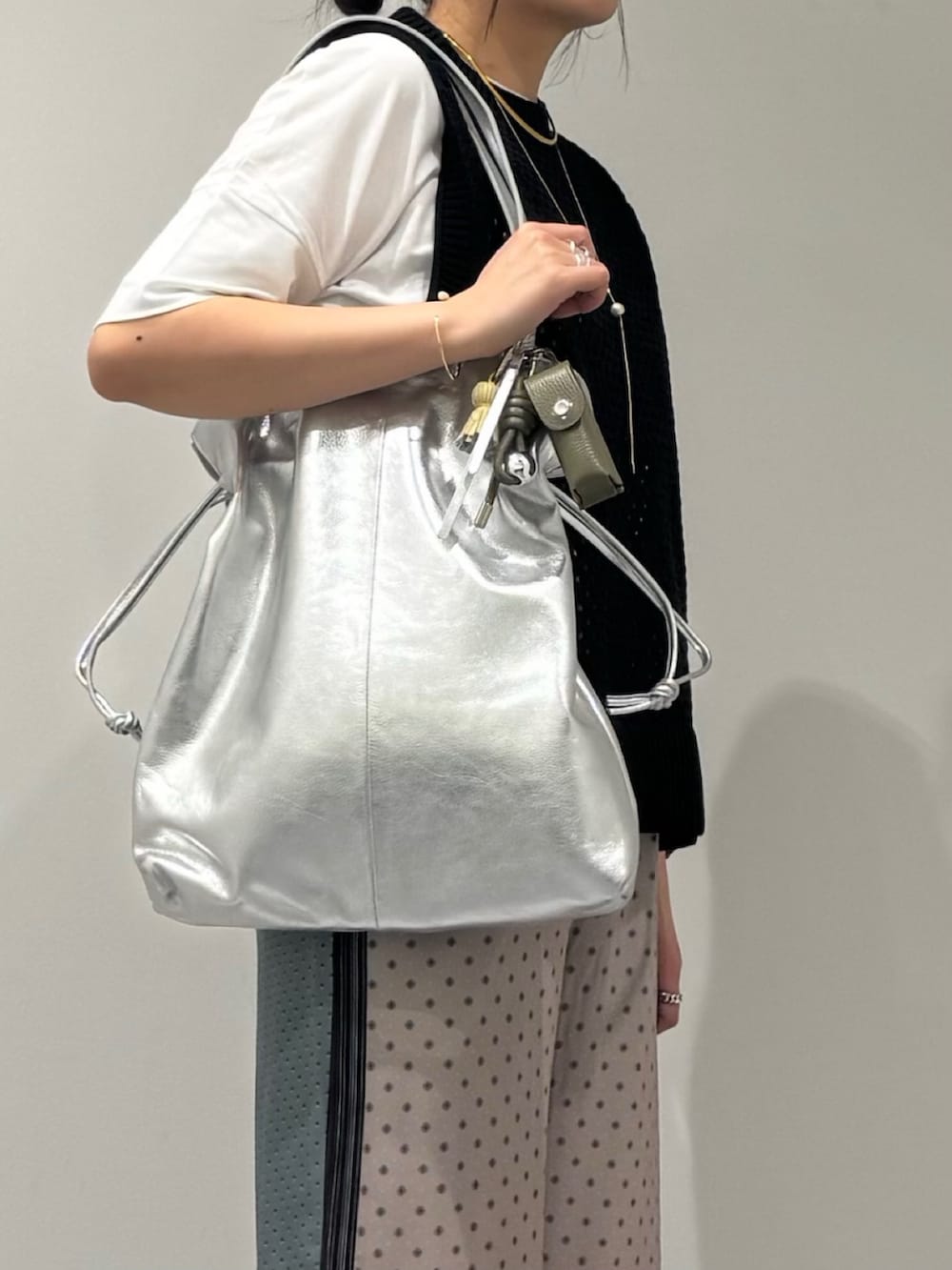 ブラック系のベスト、ベージュ系のその他パンツ、ブラック系のローファーを着用したレディースの春コーディネートの7枚目の写真