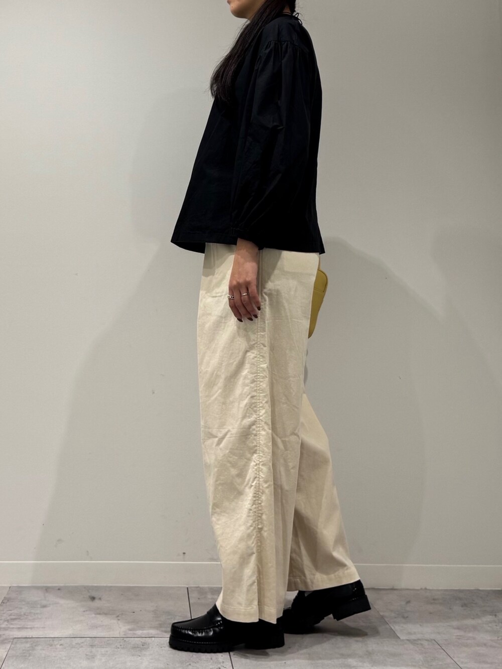 イエロー系のボストンバッグ、ブラック系のローファー、ブラック系のシャツ/ブラウスを着用したレディースの秋コーディネートの5枚目の写真