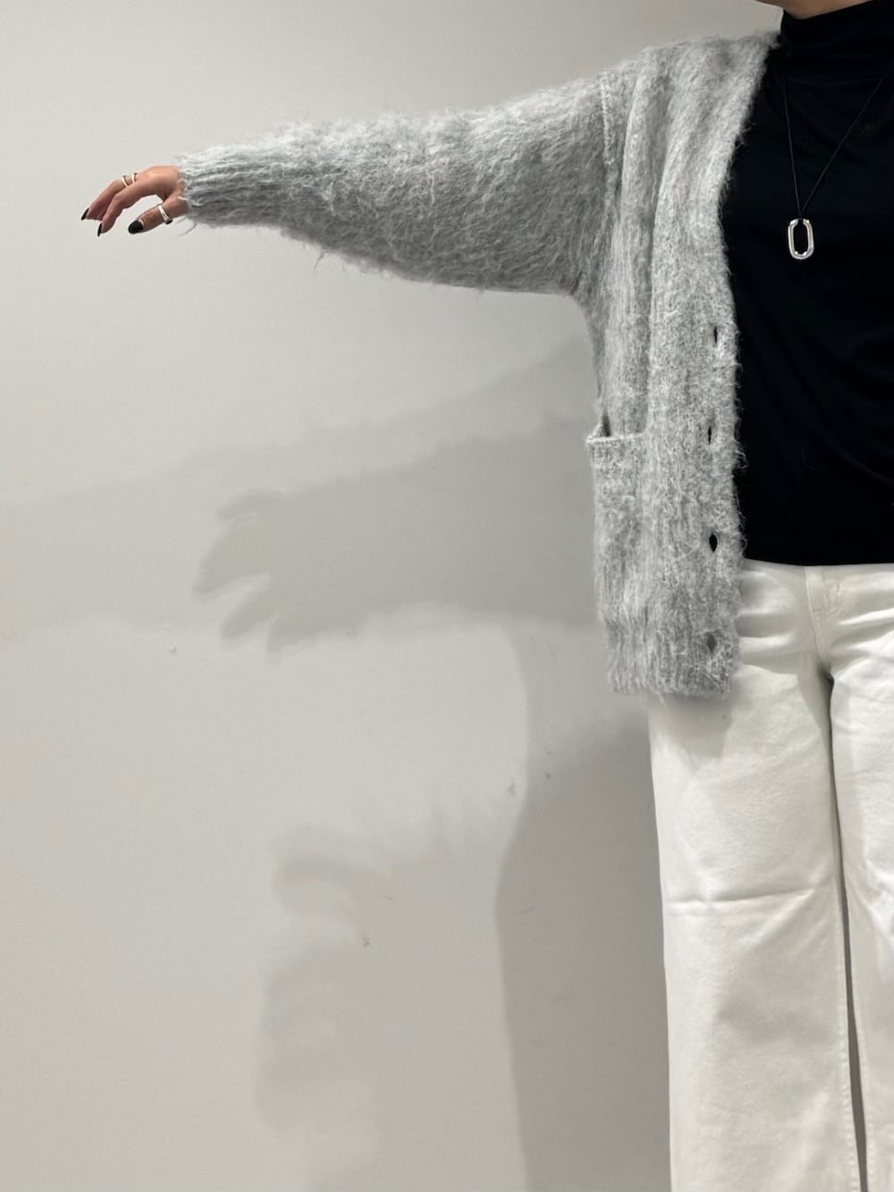 パープル系のトートバッグ、ホワイト系のデニムパンツ、ブラック系のローファーを着用したレディースの冬コーディネートの7枚目の写真