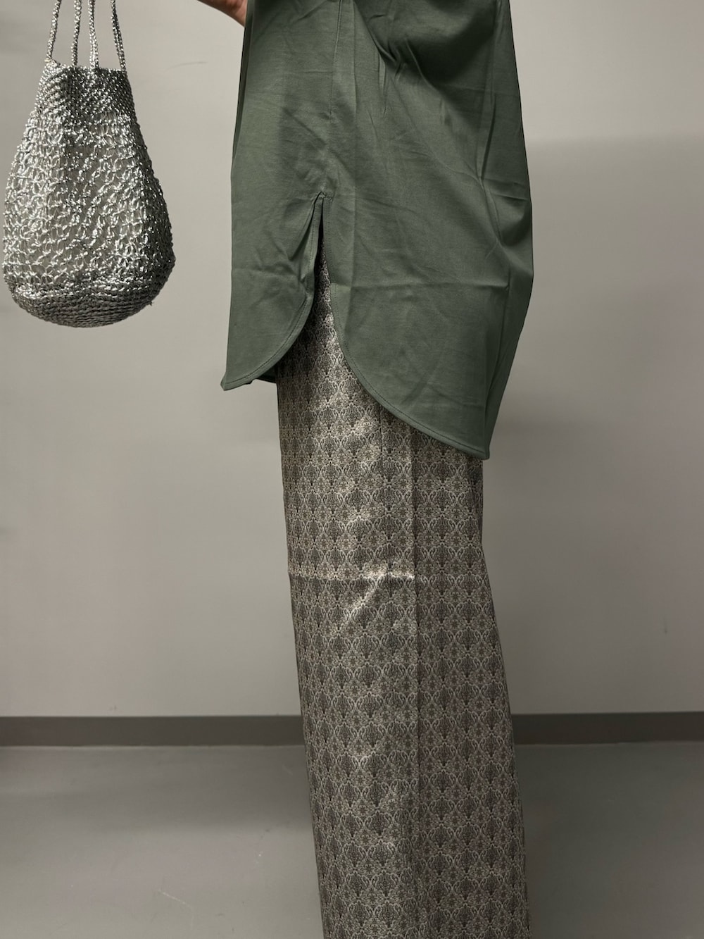 グリーン系のTシャツ/カットソー、ベージュ系のその他パンツ、シルバー系のかごバッグを着用したレディースの夏コーディネートの2枚目の写真