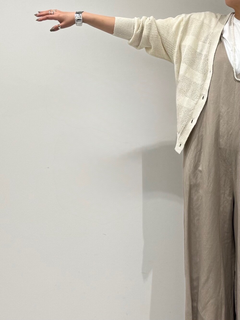 ベージュ系のサロペット/オーバーオール、ホワイト系のカーディガン/ボレロ、ベージュ系のかごバッグを着用したレディースの春コーディネートの7枚目の写真