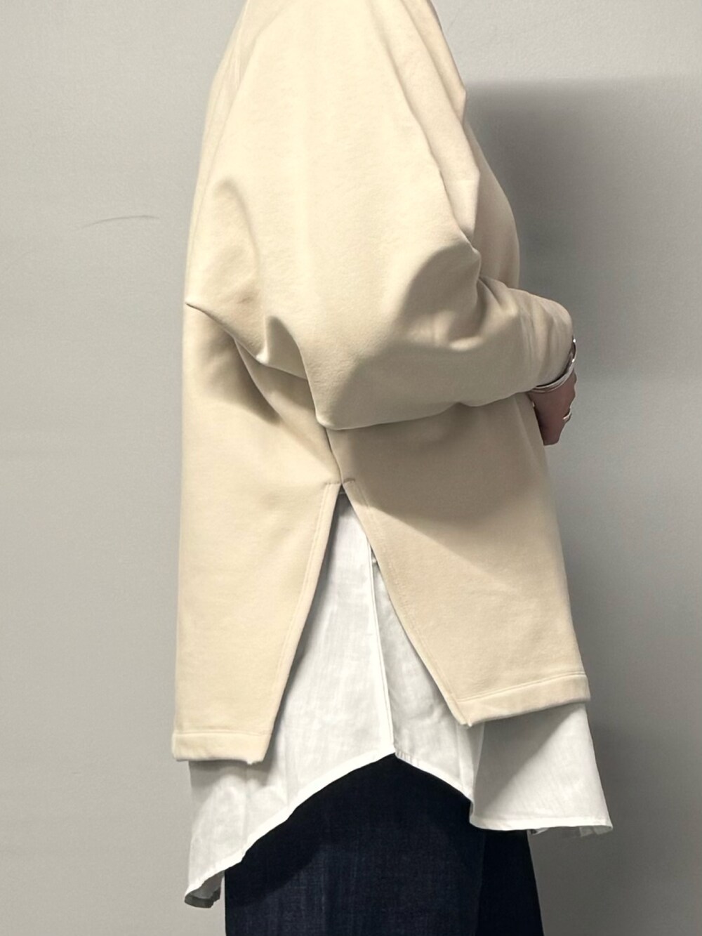 ベージュ系のスウェット、ブルー系のデニムパンツ、グレー系のトートバッグを着用したレディースの冬コーディネートの9枚目の写真