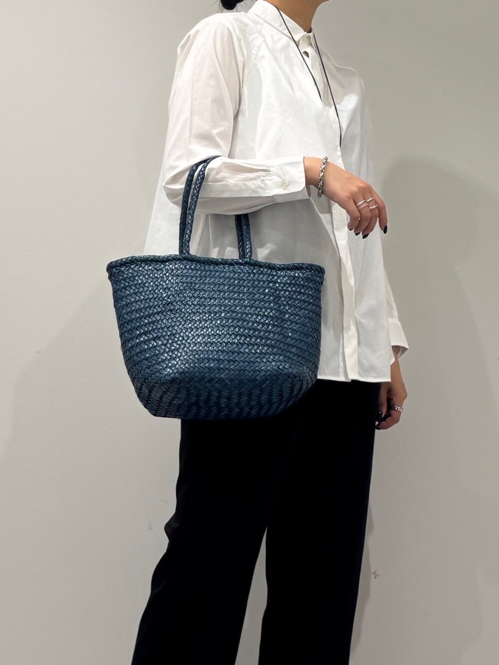 ブルー系のトートバッグ、ブラック系のその他パンツ、ホワイト系のシャツ/ブラウスを着用したレディースの秋コーディネートの9枚目の写真