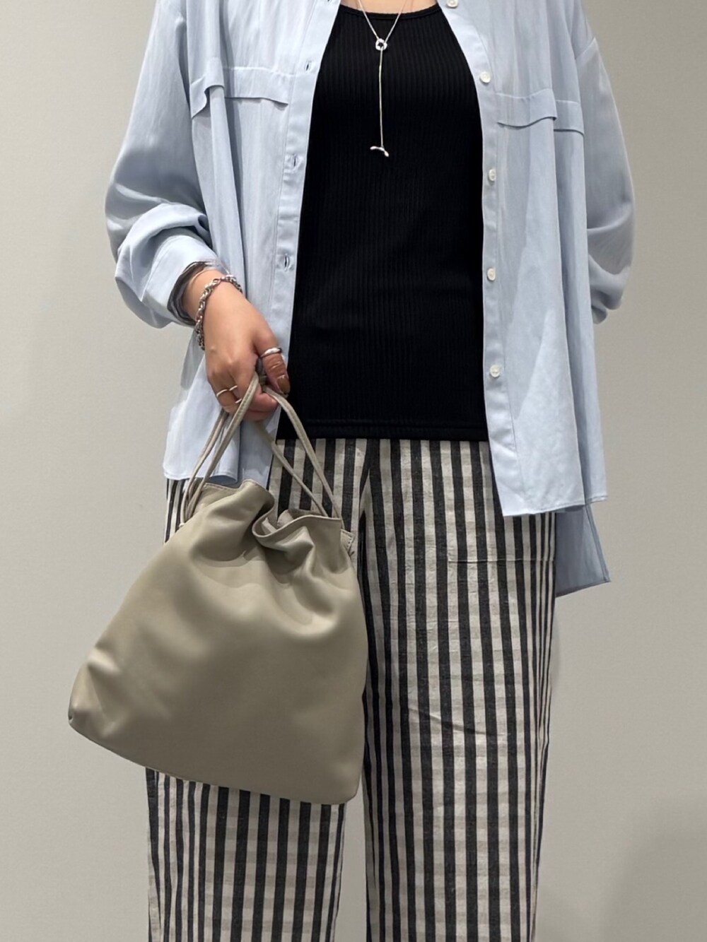 ベージュ系のショルダーバッグ、ブラック系のその他パンツ、ブラック系のサンダルを着用したレディースの秋コーディネートの7枚目の写真