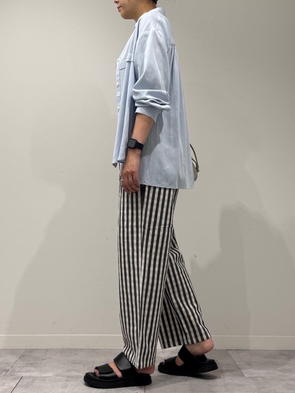 ベージュ系のショルダーバッグ、ブラック系のその他パンツ、ブラック系のサンダルを着用したレディースの秋コーディネートの5枚目の写真