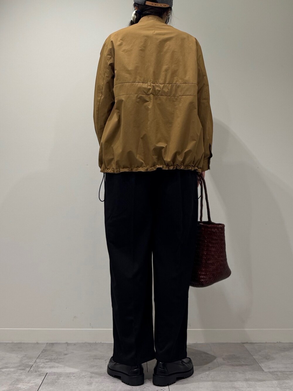 ブラウン系のトートバッグ、ブラック系のサロペット/オーバーオール、ブラック系のローファーを着用したレディースの秋コーディネートの3枚目の写真