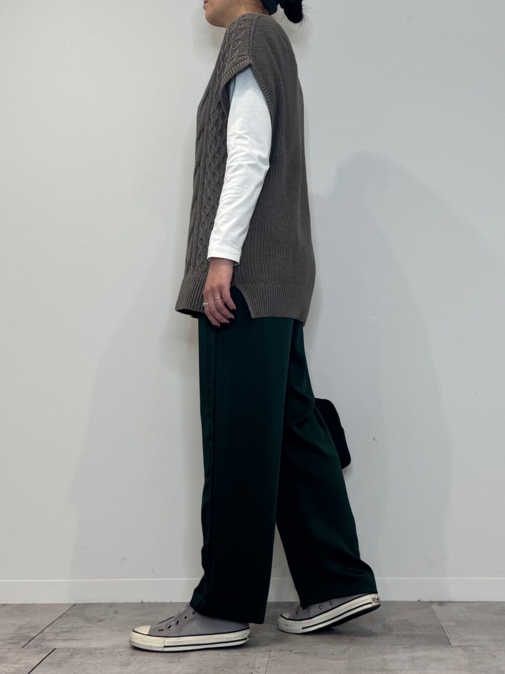 グリーン系のその他パンツ、ベージュ系のニット/セーター、ホワイト系のTシャツ/カットソーを着用したレディースの冬コーディネートの5枚目の写真