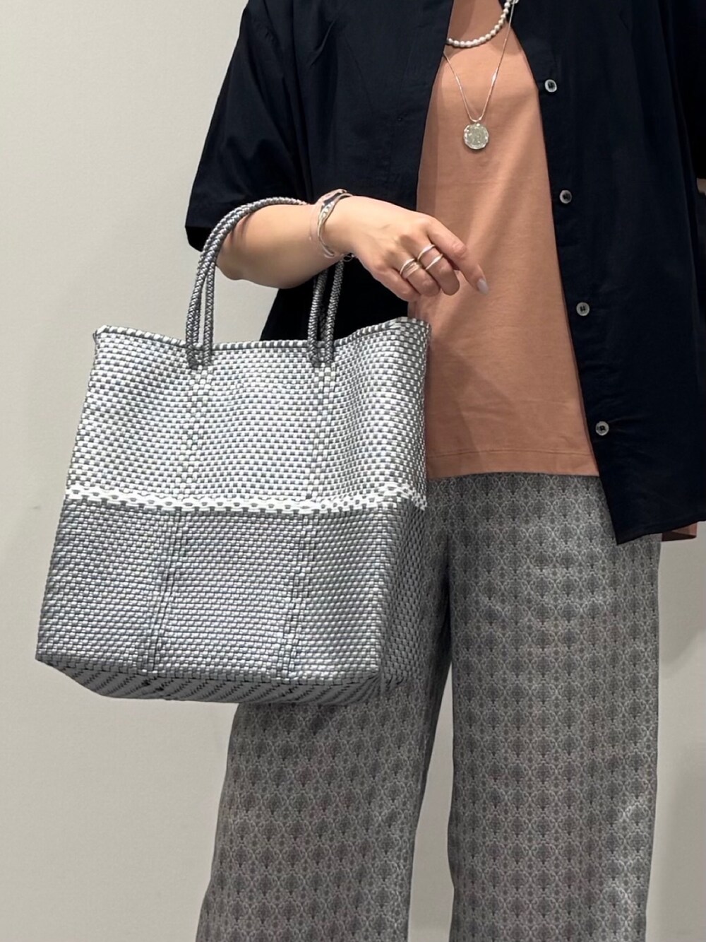 ピンク系のTシャツ/カットソー、シルバー系のかごバッグ、ベージュ系のその他パンツを着用したレディースの春コーディネートの9枚目の写真