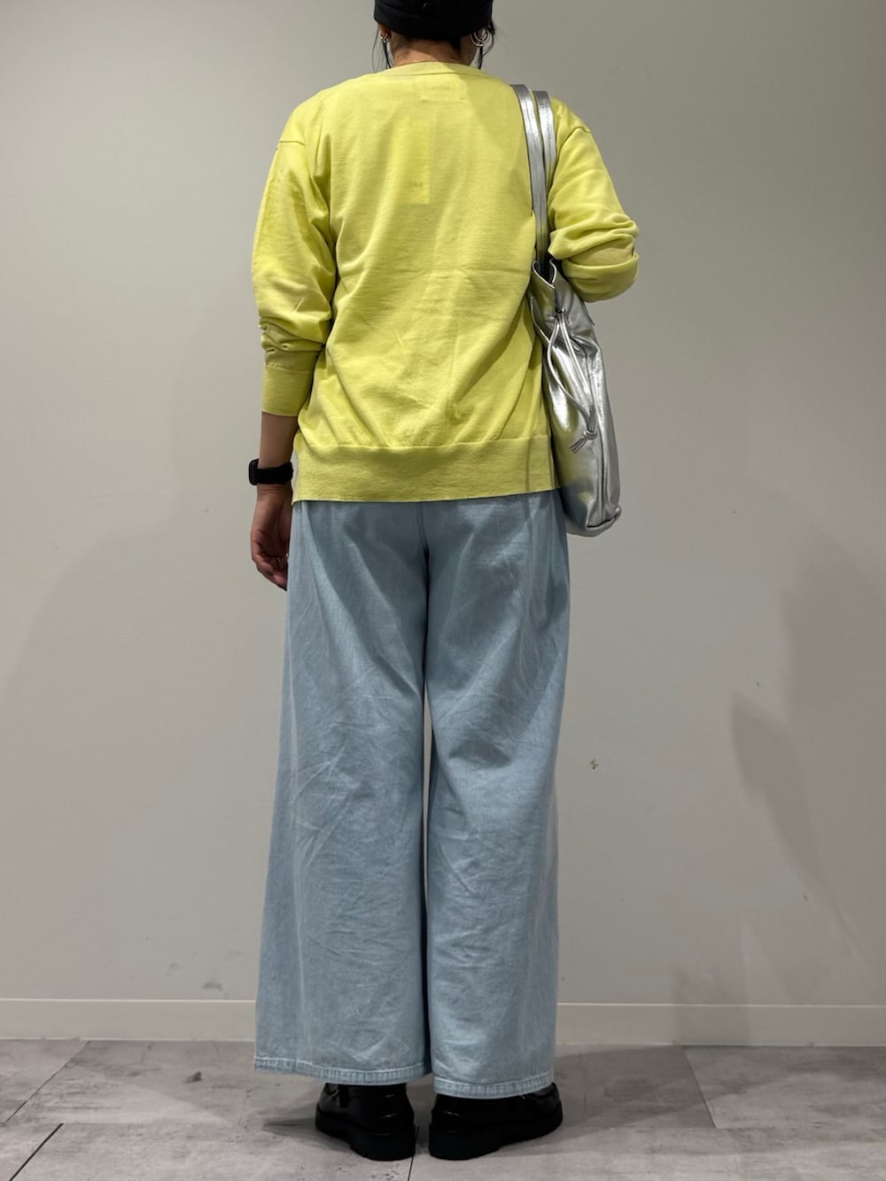 シルバー系のトートバッグ、ブラック系のローファー、ブルー系のデニムパンツを着用したレディースの春コーディネートの3枚目の写真