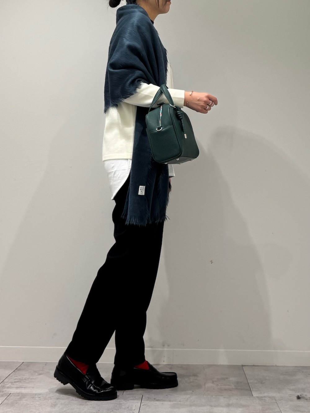 グリーン系のボストンバッグ、ブラック系のその他パンツ、ブラック系のローファーを着用したレディースの冬コーディネートの2枚目の写真