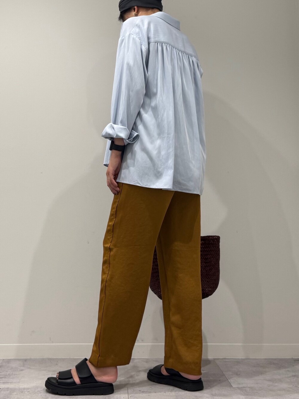 ブラウン系のトートバッグ、ブラウン系のその他パンツ、ブラック系のサンダルを着用したレディースの秋コーディネートの5枚目の写真