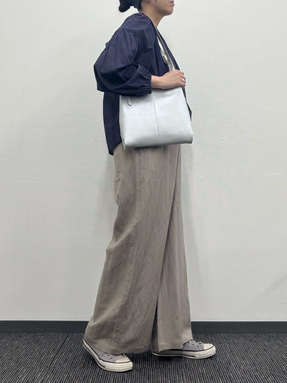 シルバー系のトートバッグ、ベージュ系のサロペット/オーバーオール、ホワイト系のTシャツ/カットソーを着用したレディースの春コーディネートの2枚目の写真