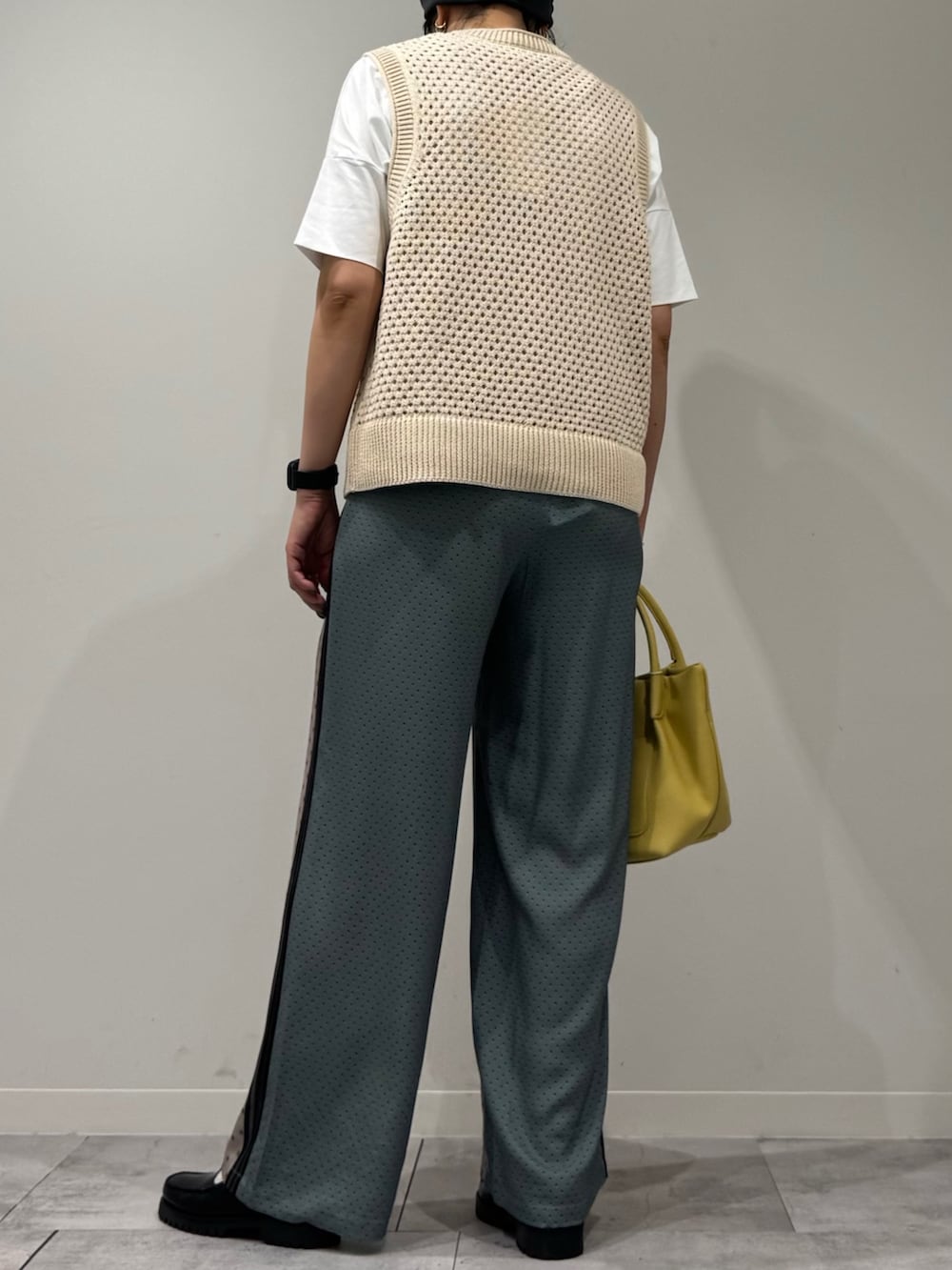 イエロー系のショルダーバッグ、ベージュ系のその他パンツ、ブラック系のローファーを着用したレディースの春コーディネートの4枚目の写真