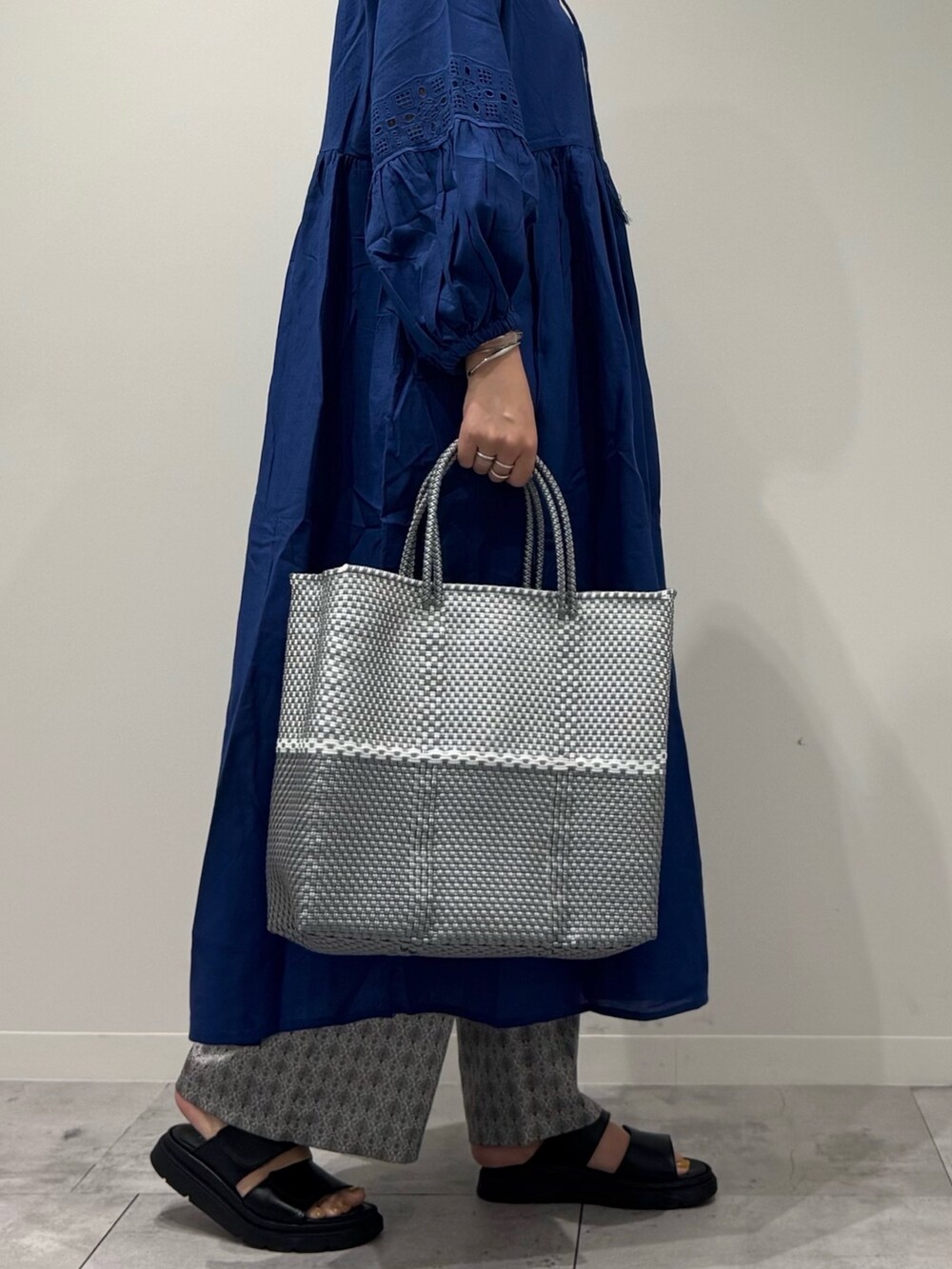 シルバー系のかごバッグ、ブラック系のサンダル、ベージュ系のその他パンツを着用したレディースの春コーディネートの9枚目の写真