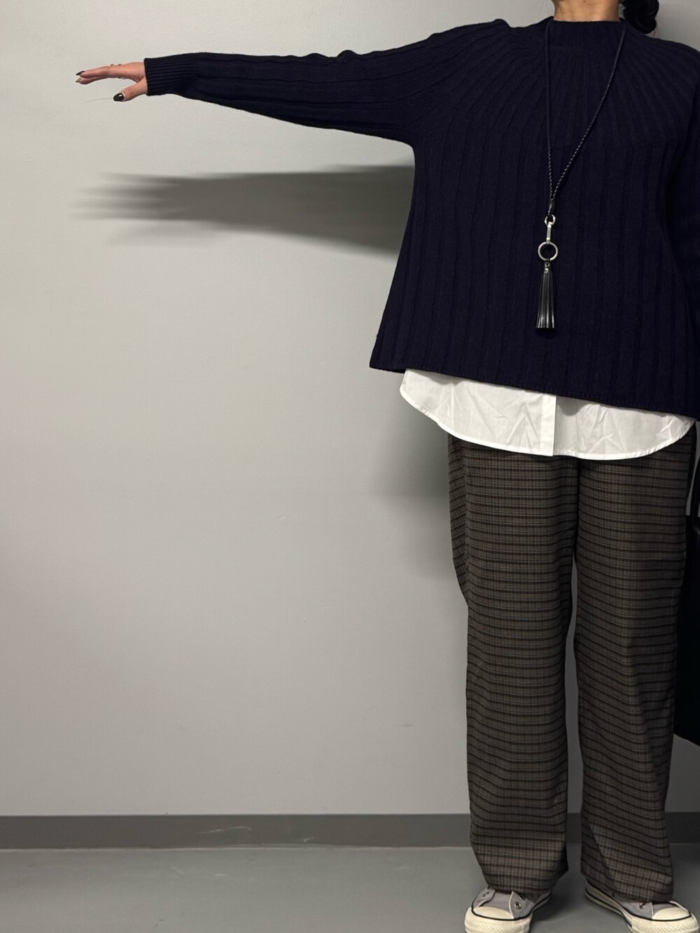 ブルー系のニット/セーター、ブラック系のトートバッグ、ブラウン系のその他パンツを着用したレディースの冬コーディネートの4枚目の写真