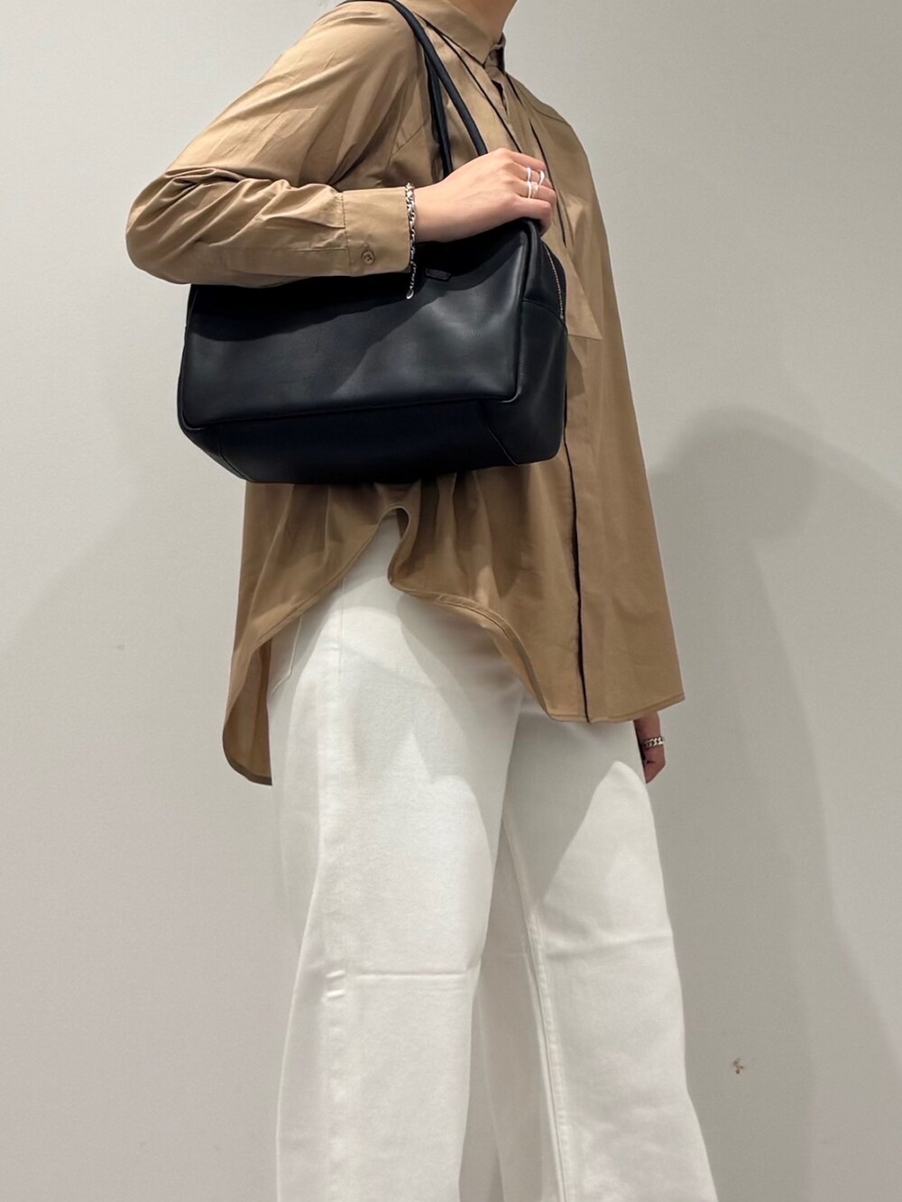 ベージュ系のシャツ/ブラウス、ホワイト系のデニムパンツ、ブラック系のボストンバッグを着用したレディースの秋コーディネートの8枚目の写真