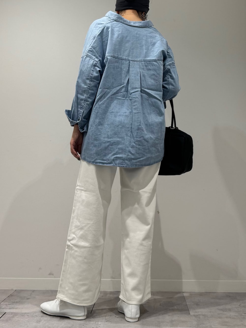 ブラック系のボストンバッグ、ホワイト系のデニムパンツ、ブルー系のシャツ/ブラウスを着用したレディースの春コーディネートの3枚目の写真