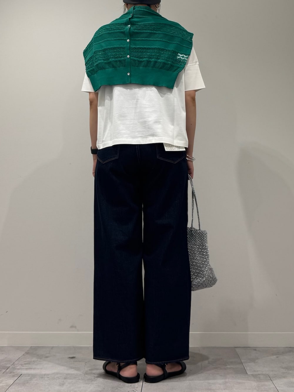 シルバー系のかごバッグ、ブルー系のデニムパンツ、ブラック系のサンダルを着用したレディースの春コーディネートの3枚目の写真