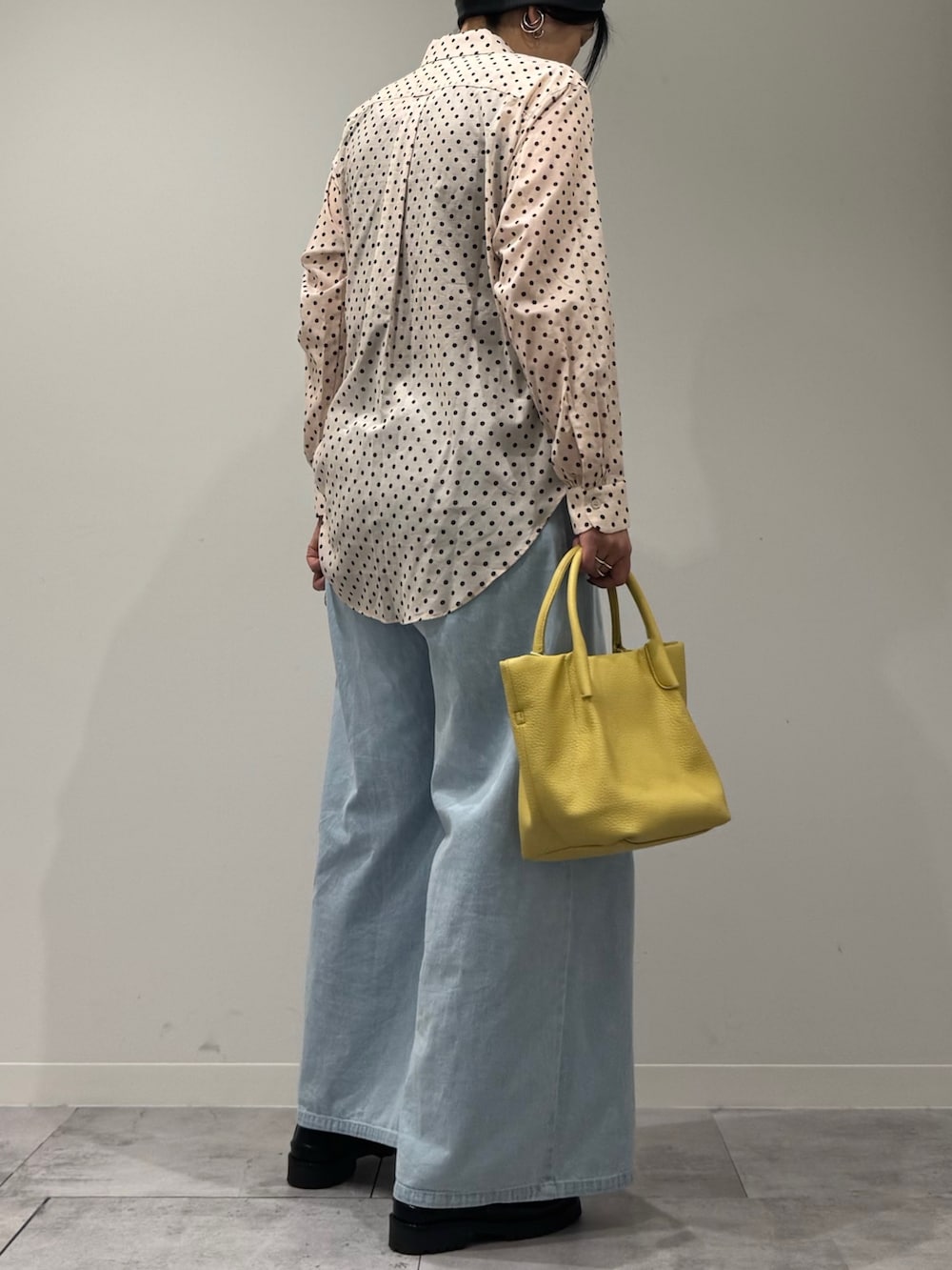 イエロー系のショルダーバッグ、ブルー系のデニムパンツ、ブラック系のローファーを着用したレディースの春コーディネートの3枚目の写真