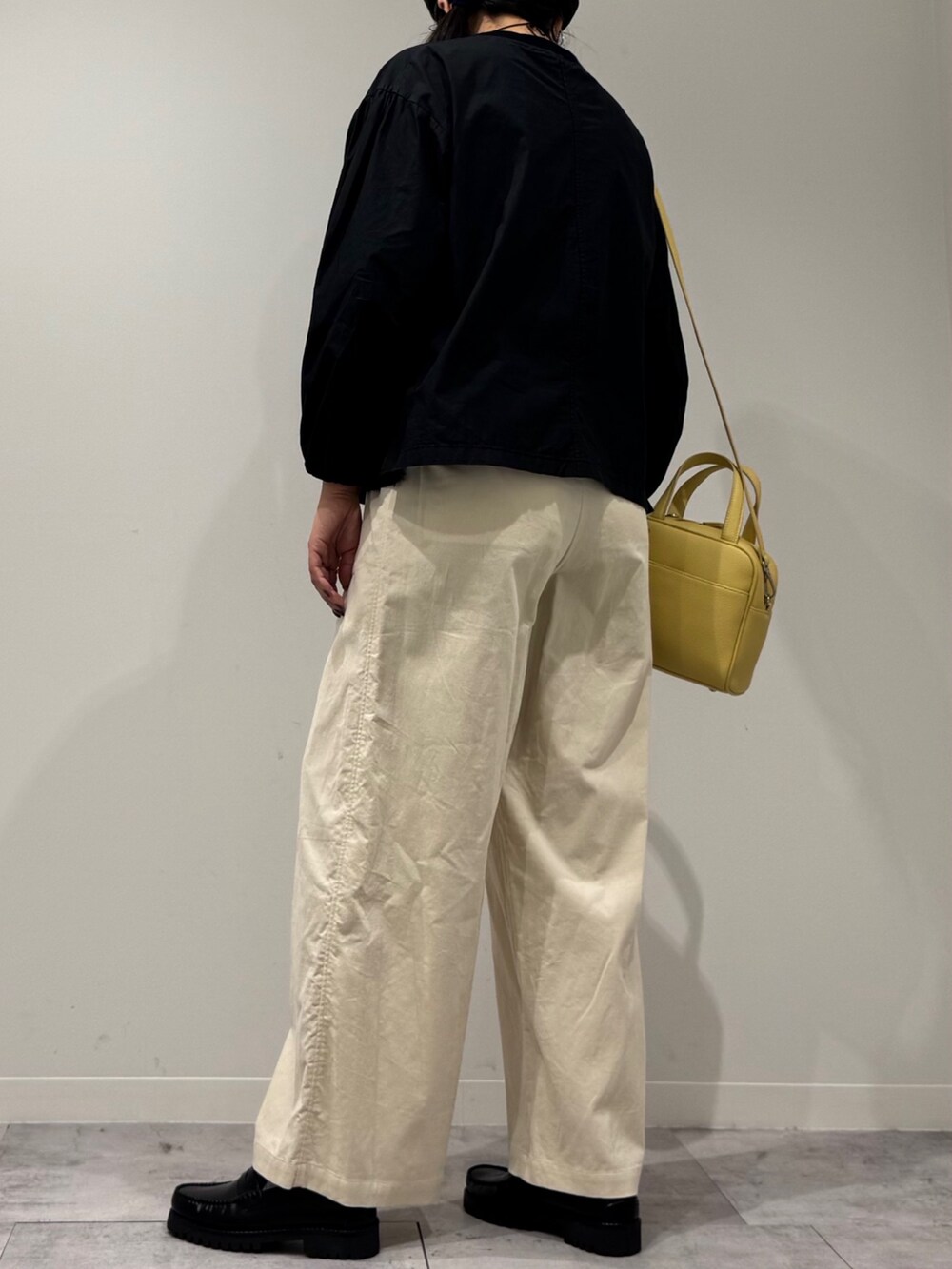 イエロー系のボストンバッグ、ブラック系のローファー、ブラック系のシャツ/ブラウスを着用したレディースの秋コーディネートの4枚目の写真