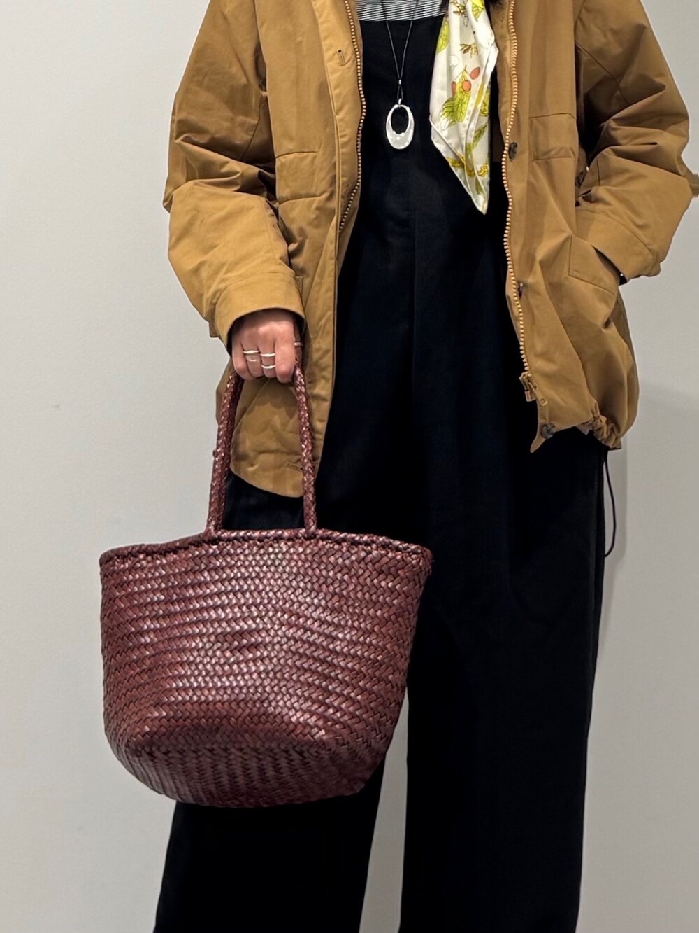 ブラウン系のトートバッグ、ブラック系のサロペット/オーバーオール、ブラック系のローファーを着用したレディースの秋コーディネートの7枚目の写真