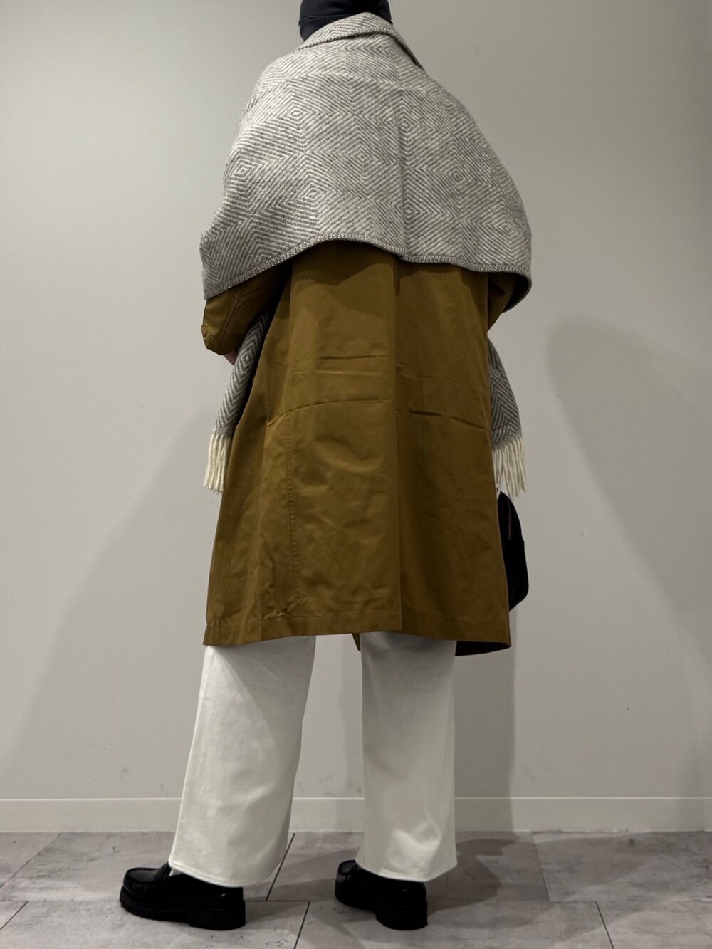 ブラック系のボストンバッグ、ベージュ系のダウンジャケット/コート、ホワイト系のデニムパンツを着用したレディースの冬コーディネートの4枚目の写真