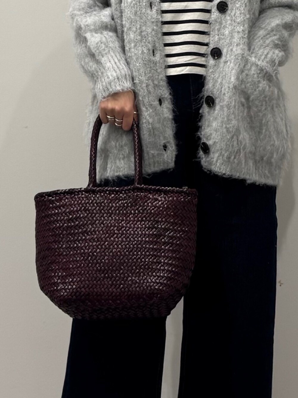 パープル系のトートバッグ、ブルー系のデニムパンツ、ブラック系のTシャツ/カットソーを着用したレディースの冬コーディネートの7枚目の写真