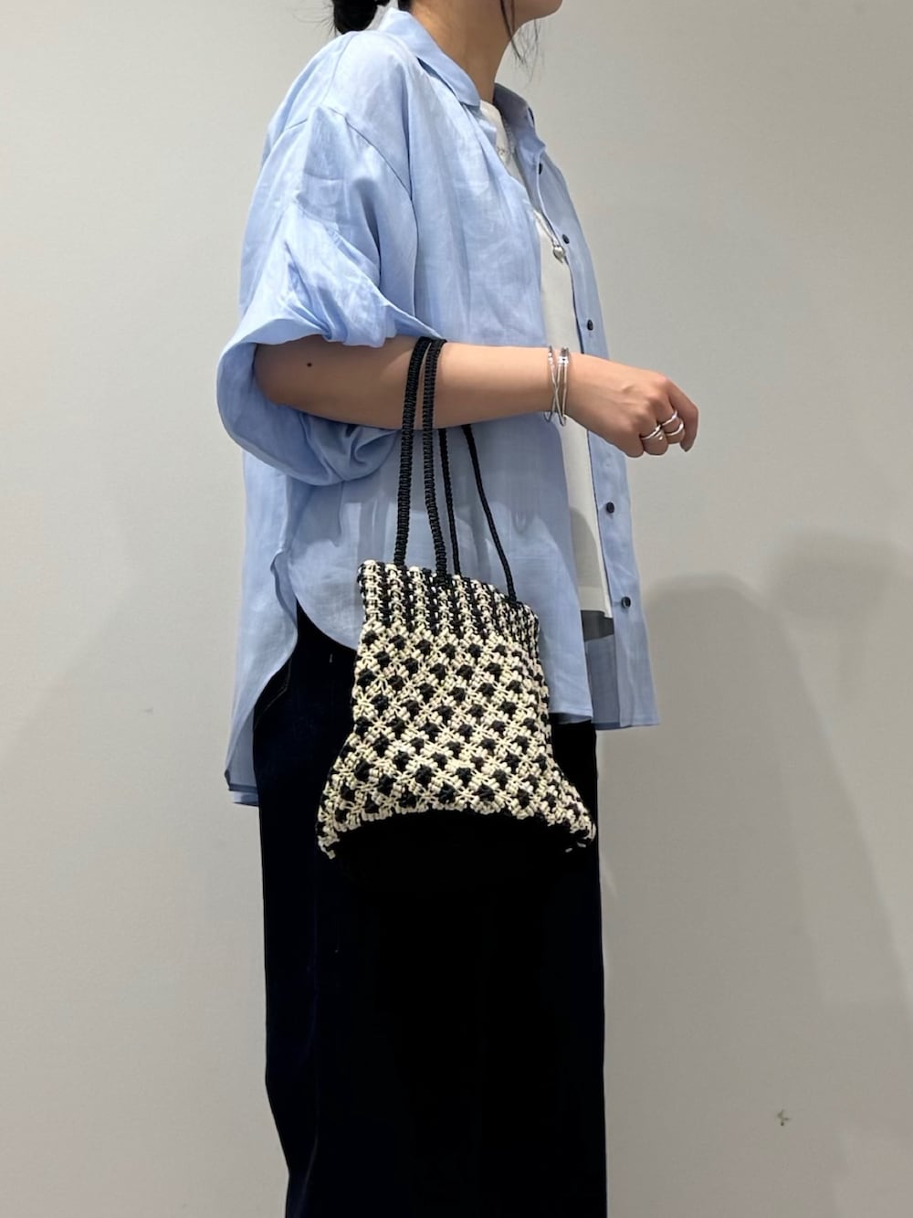 その他のかごバッグ、ブルー系のデニムパンツ、ブラック系のサンダルを着用したレディースの春コーディネートの8枚目の写真