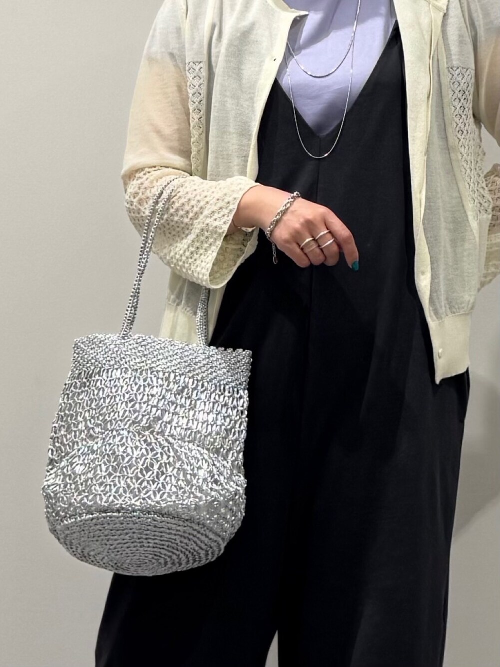 シルバー系のかごバッグ、グレー系のサロペット/オーバーオール、ブラック系のサンダルを着用したレディースの秋コーディネートの7枚目の写真